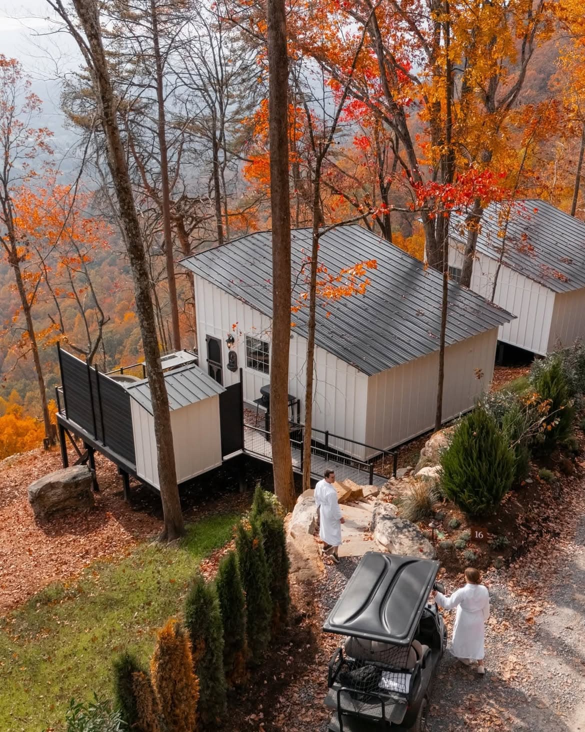 Couple arriving at their private treehouse cabin surrounded by fall foliage