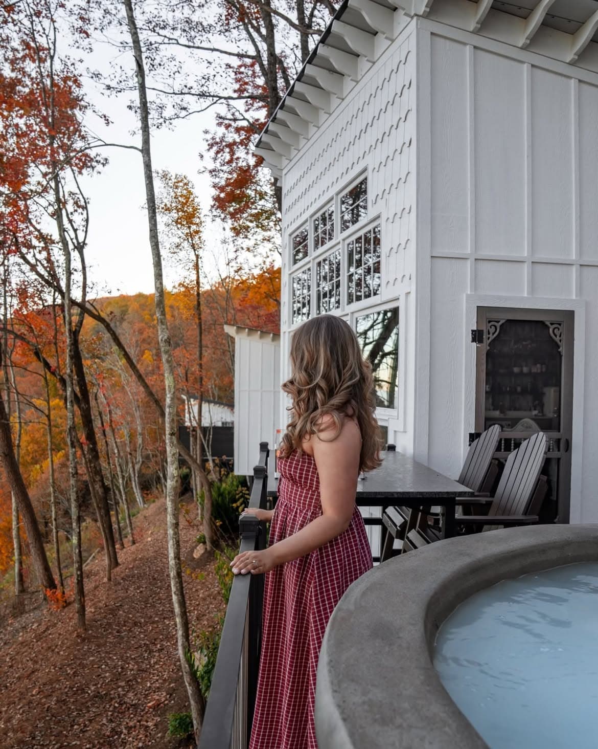 Guest on treehouse deck overlooking fall foliage at BOLT FARM Treehouse