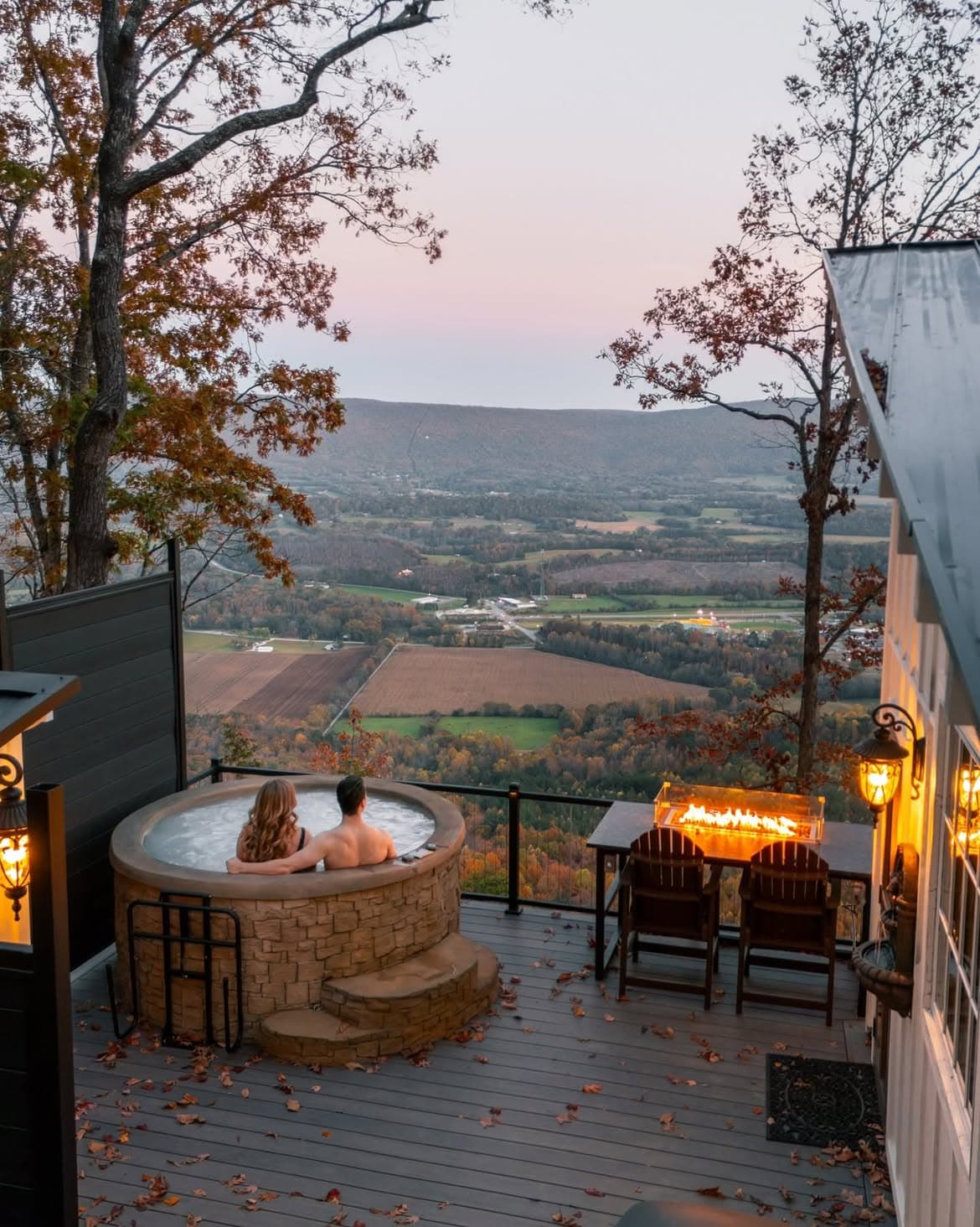 Couple in hot tub overlooking Sequatchie Valley with fire pit burning, fall colors at BOLT FARM Treehouse